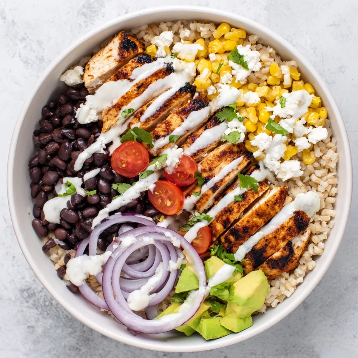 Protein packed street corn chicken bowl featuring spiced grilled chicken, sweet corn kernels, creamy avocado, and tangy lime sauce