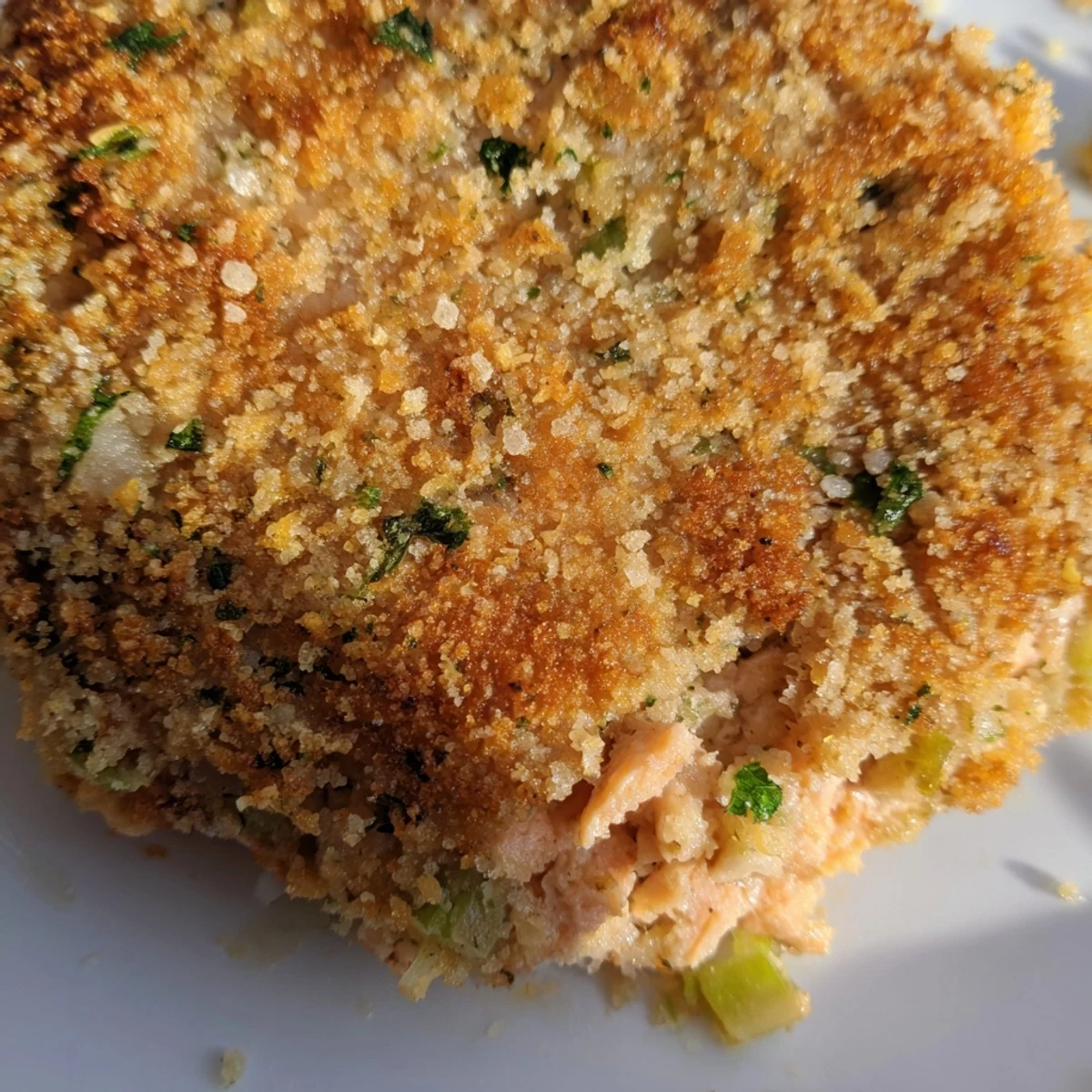 Plate of tender easy salmon cakes garnished with parsley and creamy tartar sauce dipping