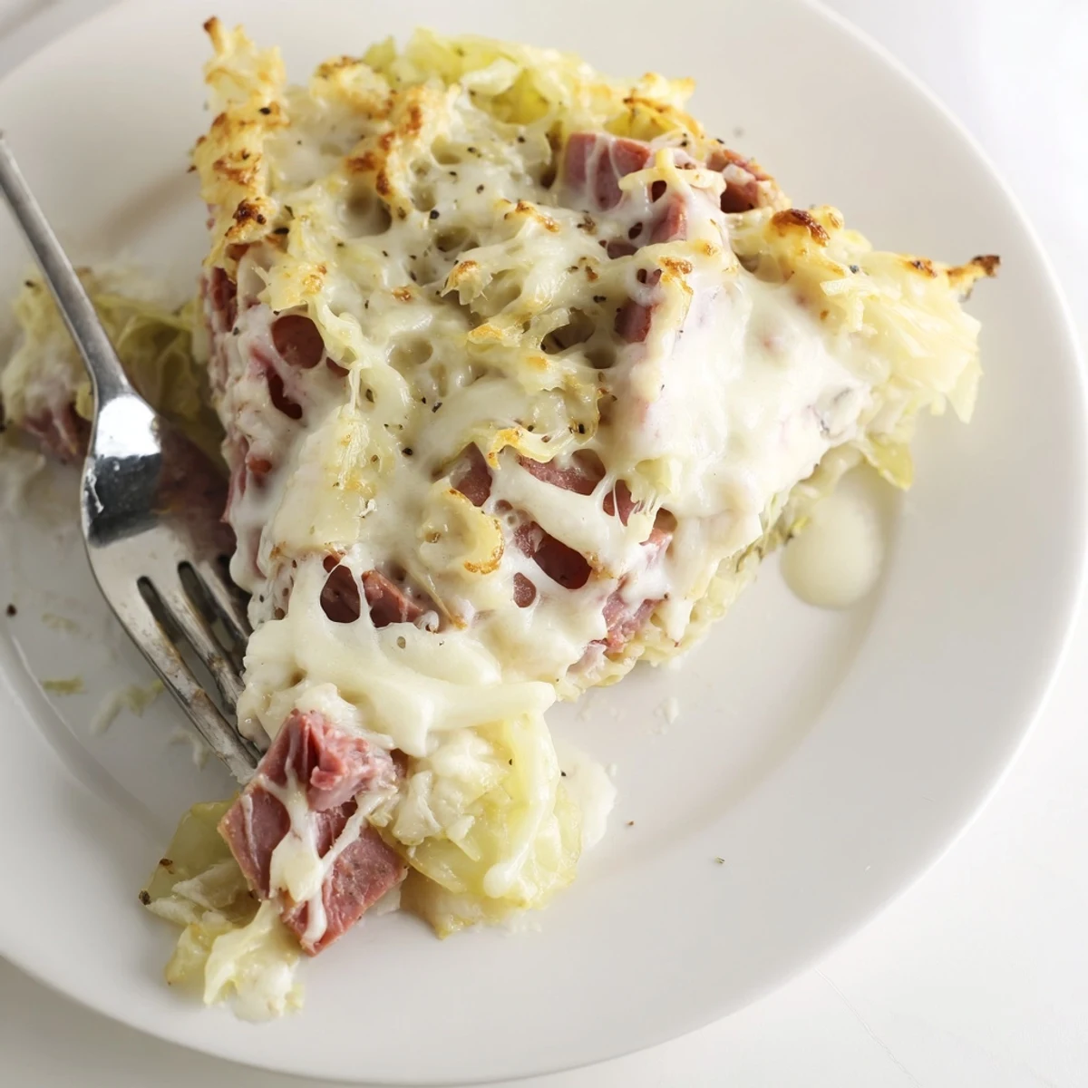 Hearty corned beef cabbage parmesan bake served piping hot showing golden brown cheesy crust and creamy layers