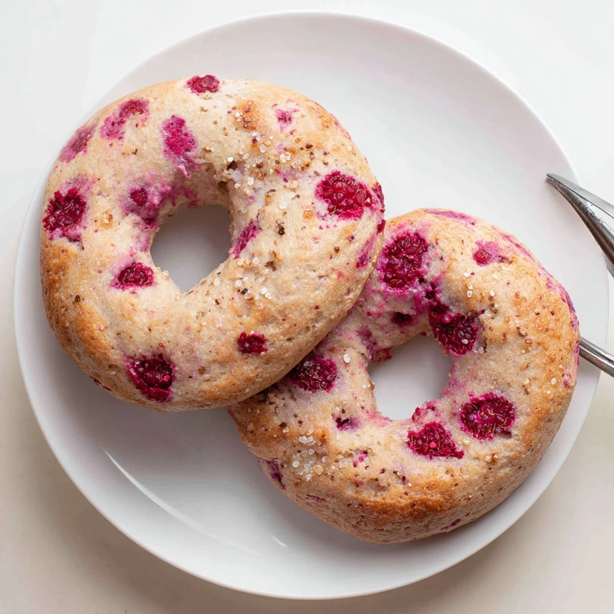 Golden brown raspberry sourdough bagels topped with sparkling sugar, ready for breakfast