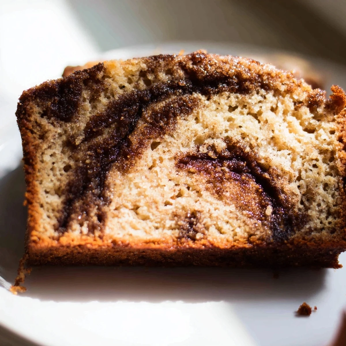 Golden slice of cinnamon sugar swirl banana bread showing moist tender crumb and marbled spiced interior
