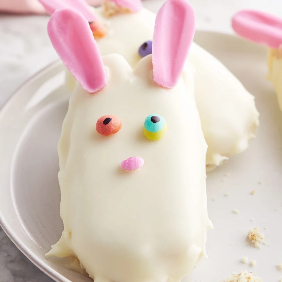 Creamy white chocolate bunny cakesicles decorated with sprinkles for festive Easter treats