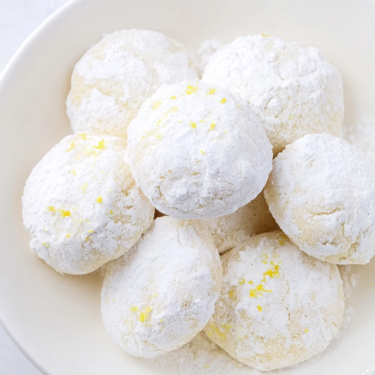 Buttery lemon meltaways with golden edges sitting on a wire cooling rack