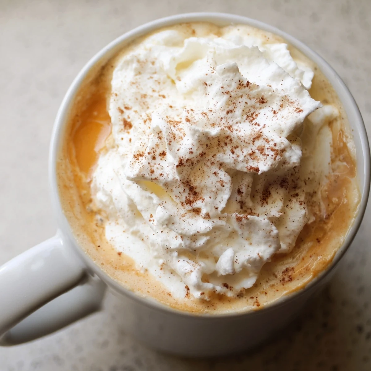 Homemade Pumpkin Spice Latte topped with whipped cream and cinnamon dusting