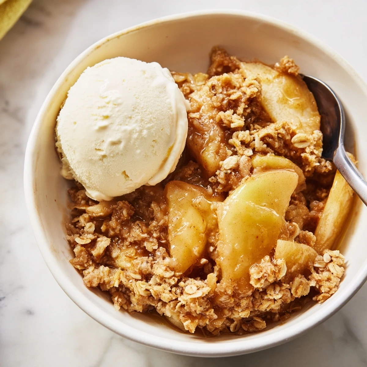 Creamy whipped cream melting over tender cinnamon apples in a comforting Crockpot Apple Crisp