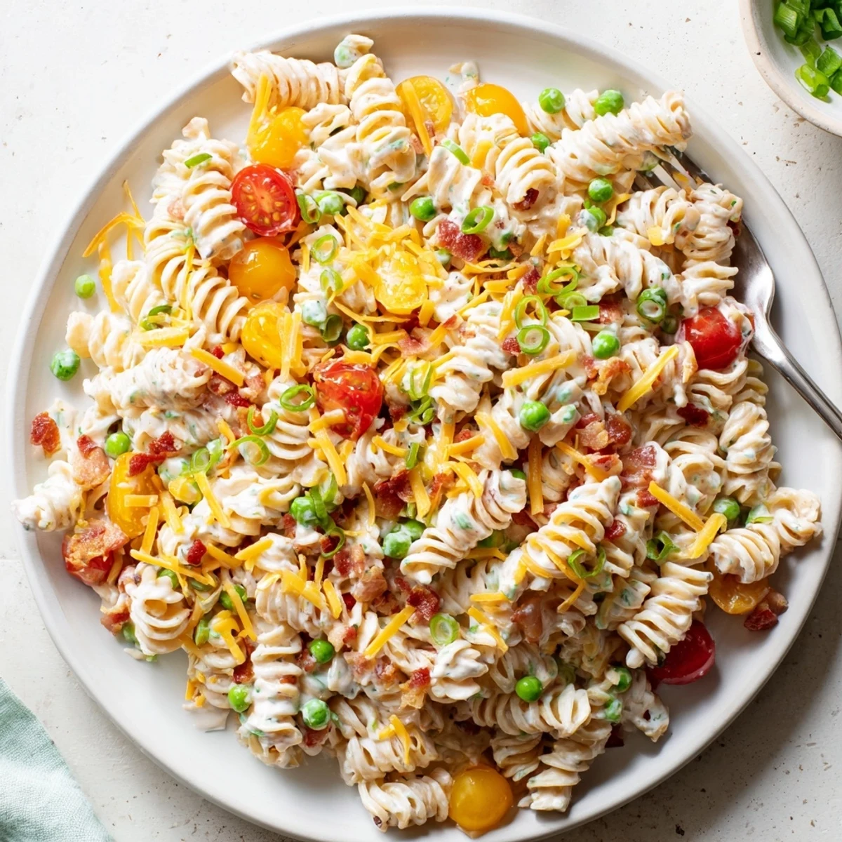 Colorful crack pasta salad mounded in a bowl with cherry tomatoes and cheddar