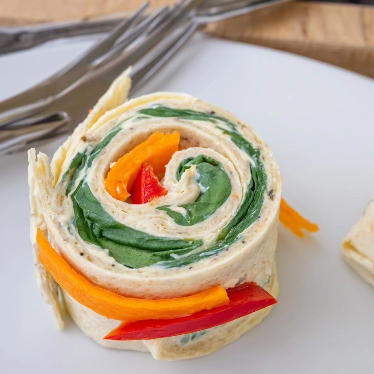 Pinwheel Sandwiches on a platter with colorful veggies, chilled and sliced.
