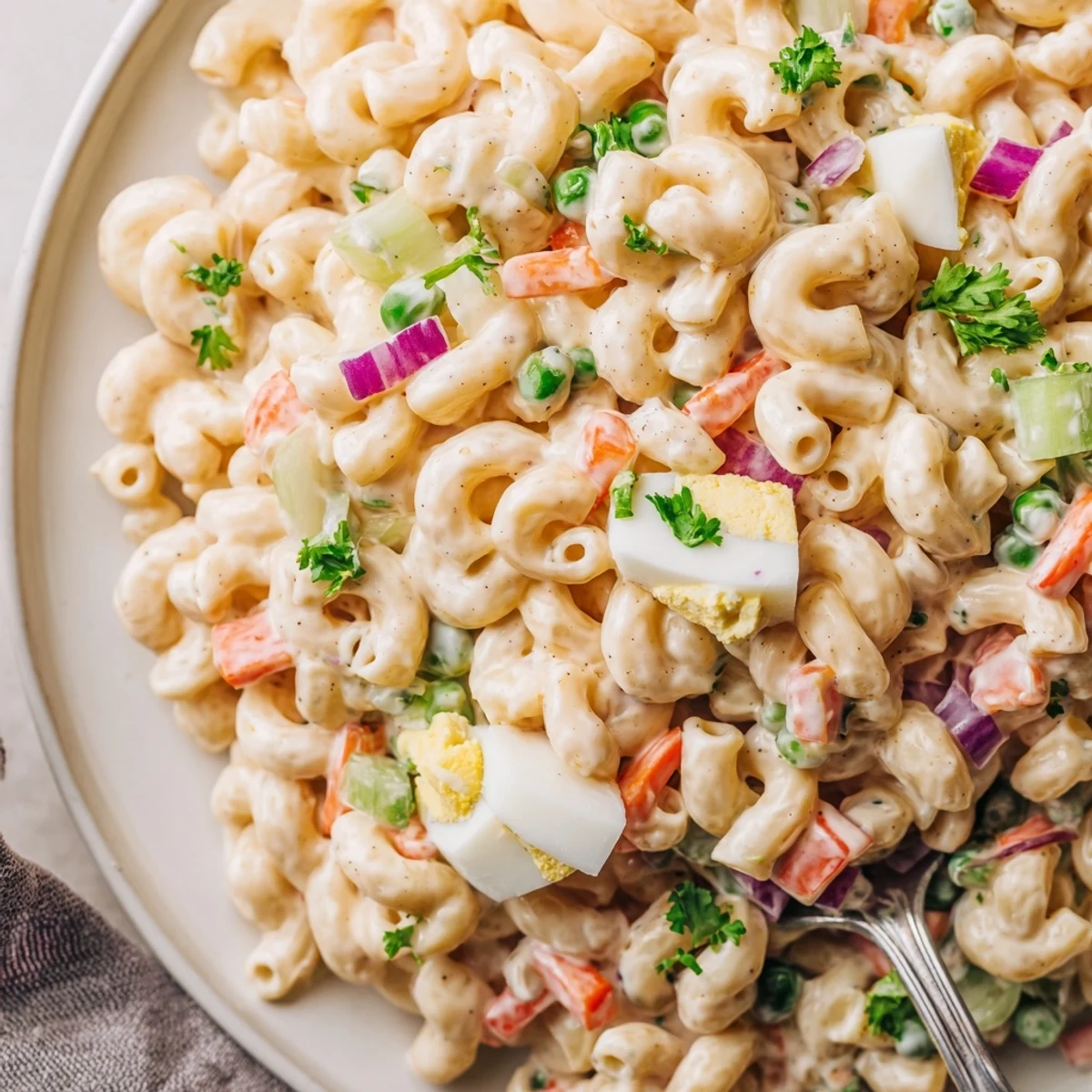 Chilled Macaroni Salad tossed in tangy Dijon-mayo dressing, topped with chopped eggs.
