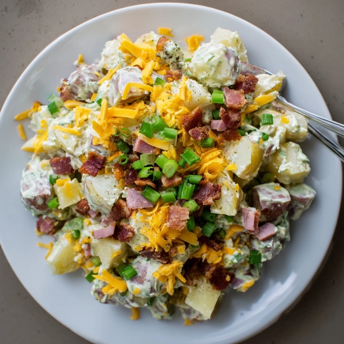 Warm Beef Bacon Loaded Potato Salad dotted with sharp cheddar and scallions.