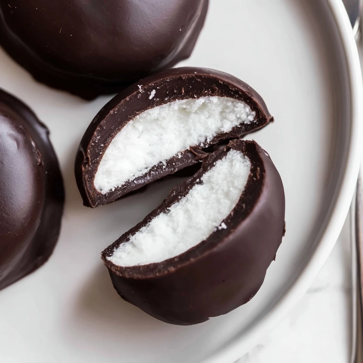 Glossy dark chocolate coated Peppermint Patties sitting on parchment, cool mint aroma
