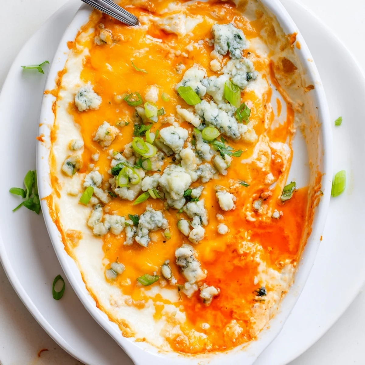 Golden white bean buffalo dip bubbling with melted cheddar and blue cheese topping