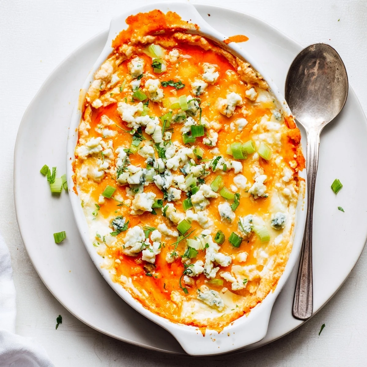 Creamy white bean buffalo dip appetizer garnished with fresh green onions and parsley
