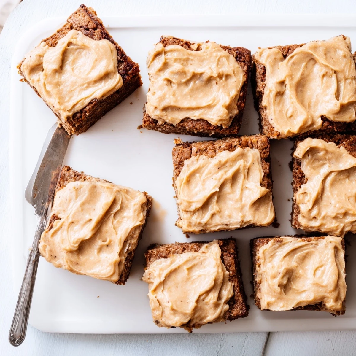 Golden square of banana bread brownies swirled with nutty brown butter frosting, ready to serve