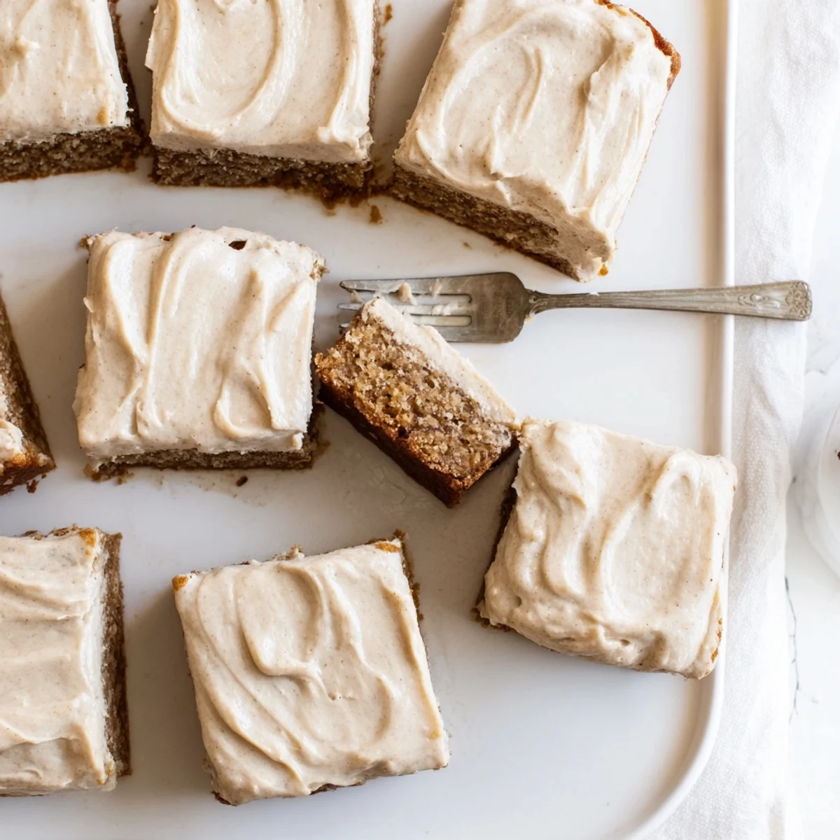 Moist banana bread brownie bar with caramelized brown butter frosting drizzled over the fudgy top