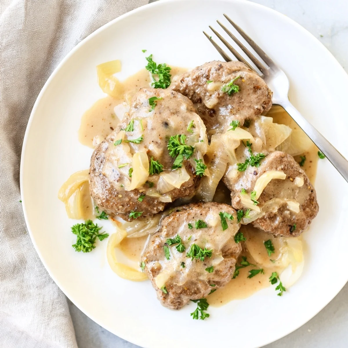 Golden brown cube steak smothered in rich onion gravy served over creamy mashed potatoes