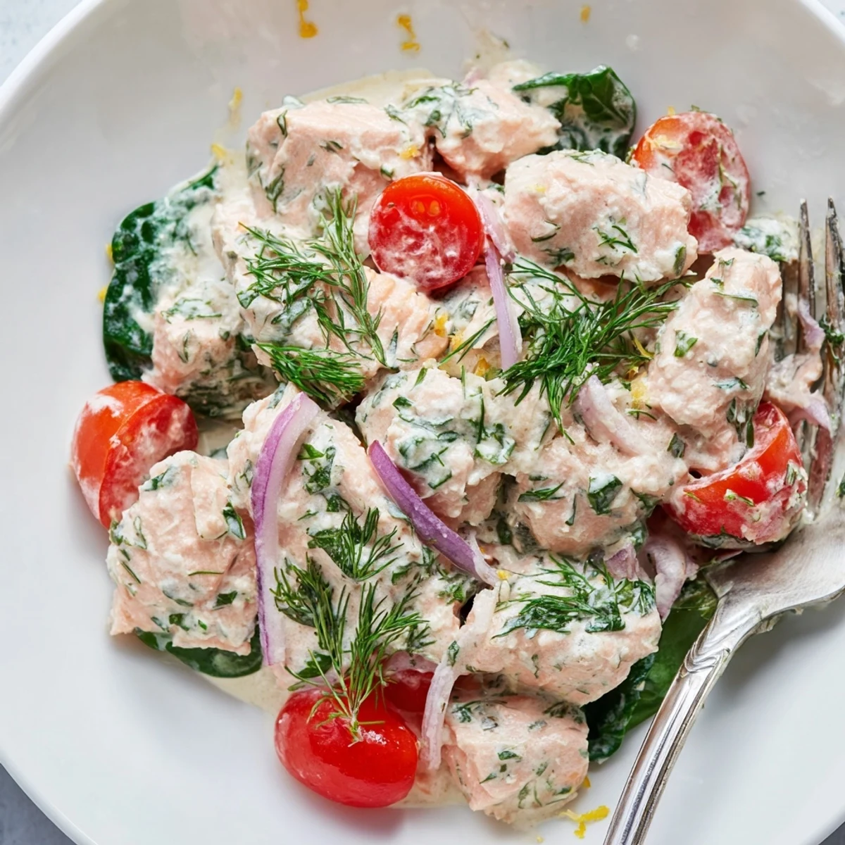 Healthy creamy leftover salmon recipe served steaming in a skillet with bright chives
